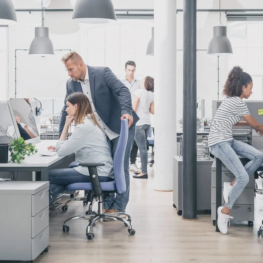 Office with workers working together, with their Mac computers on desks