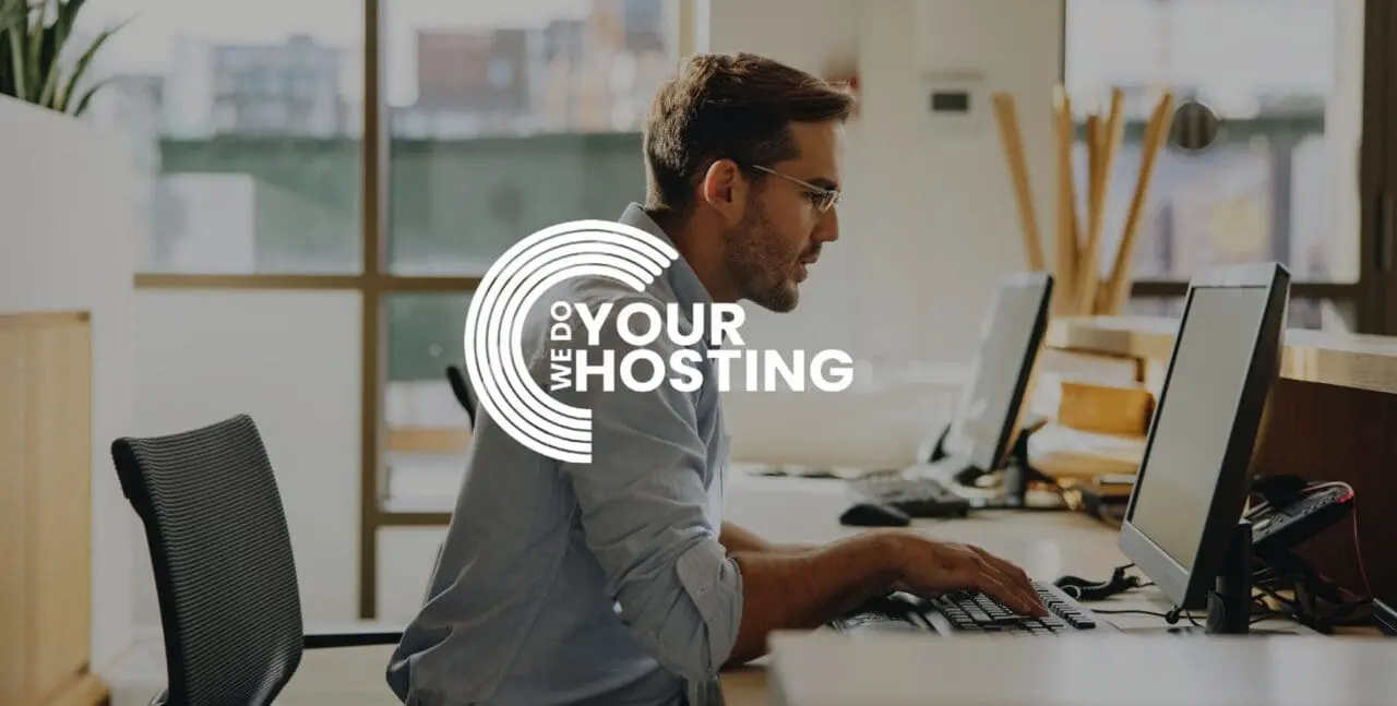 WeDoYourHosting white logo on background of businessman sat at computer at work desk