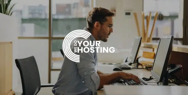 WeDoYourHosting white logo on background of businessman sat at computer at work desk