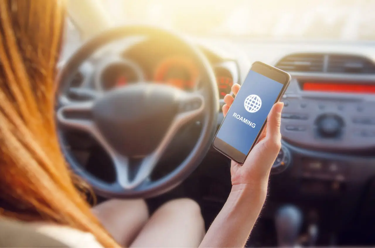 closeup of young woman checking roaming on mobile phone.