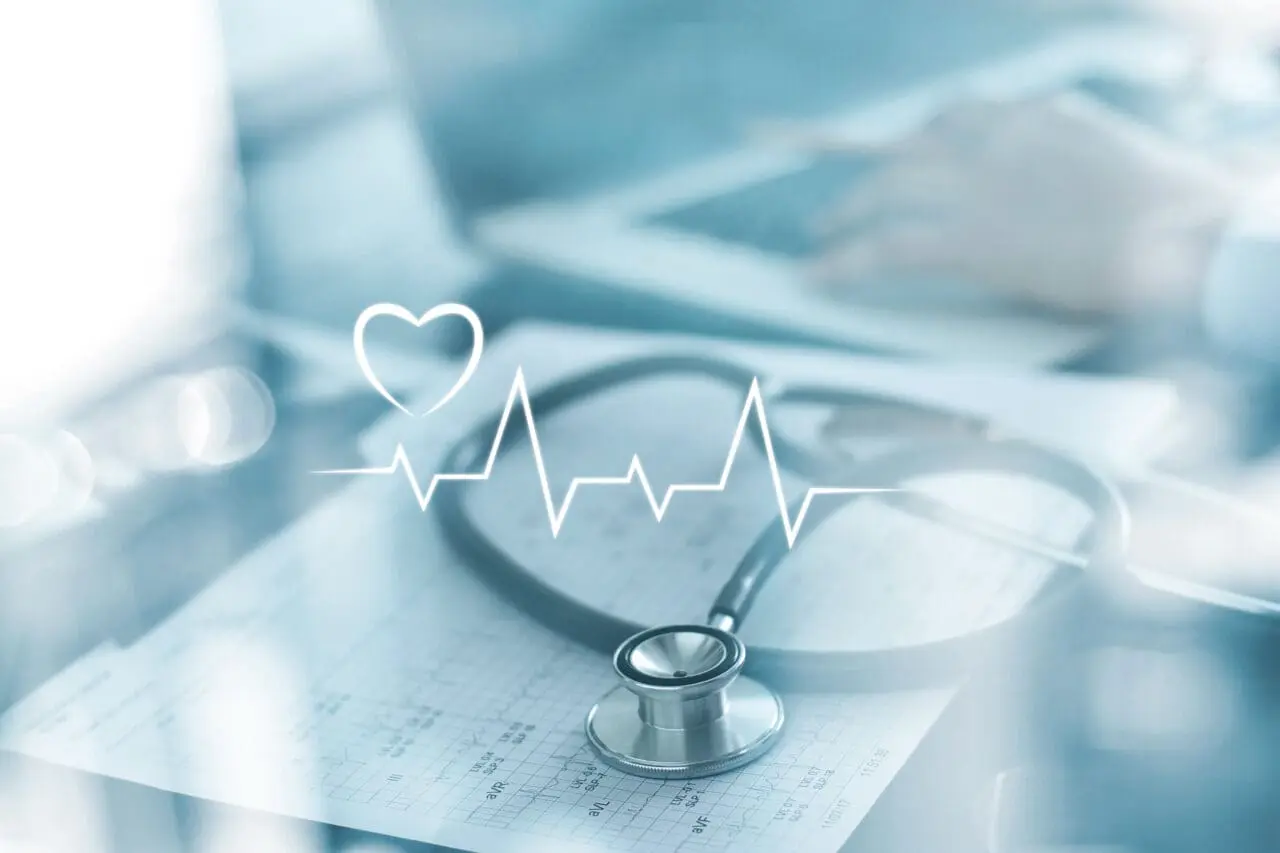 Stethoscope with heart beat report and doctor analyzing checkup