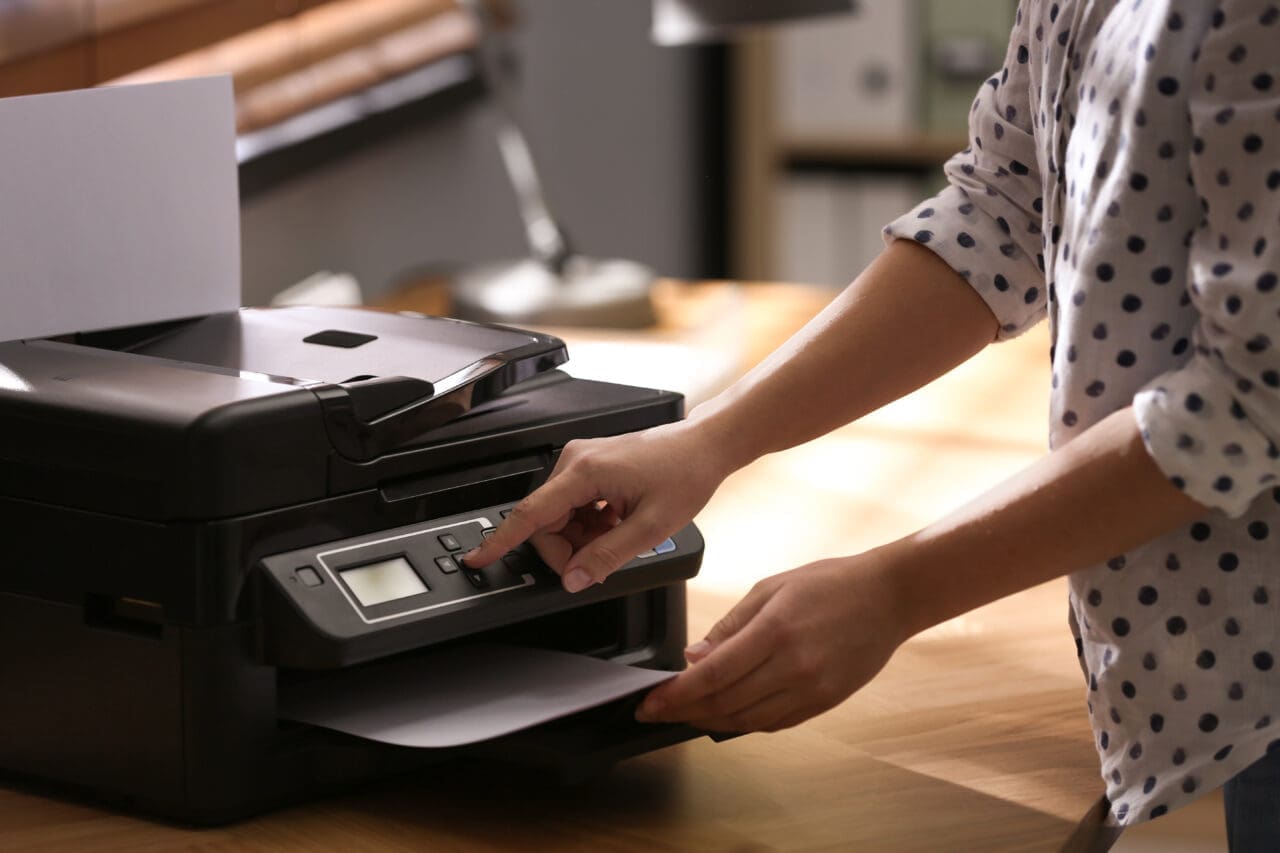 Employee using modern printer in office, closeup