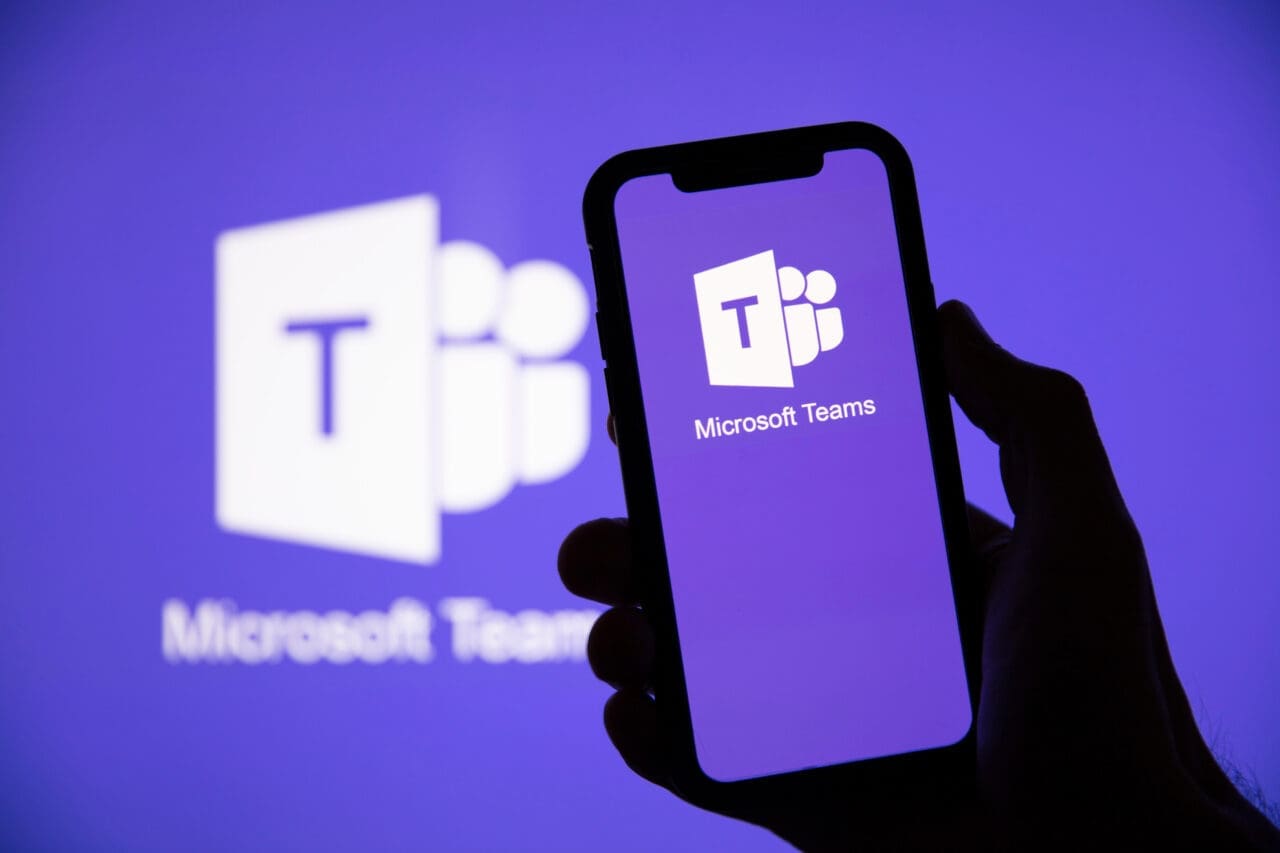 Microsoft teams logo on a mobile phone screen, on a background with the Microsoft Teams logo