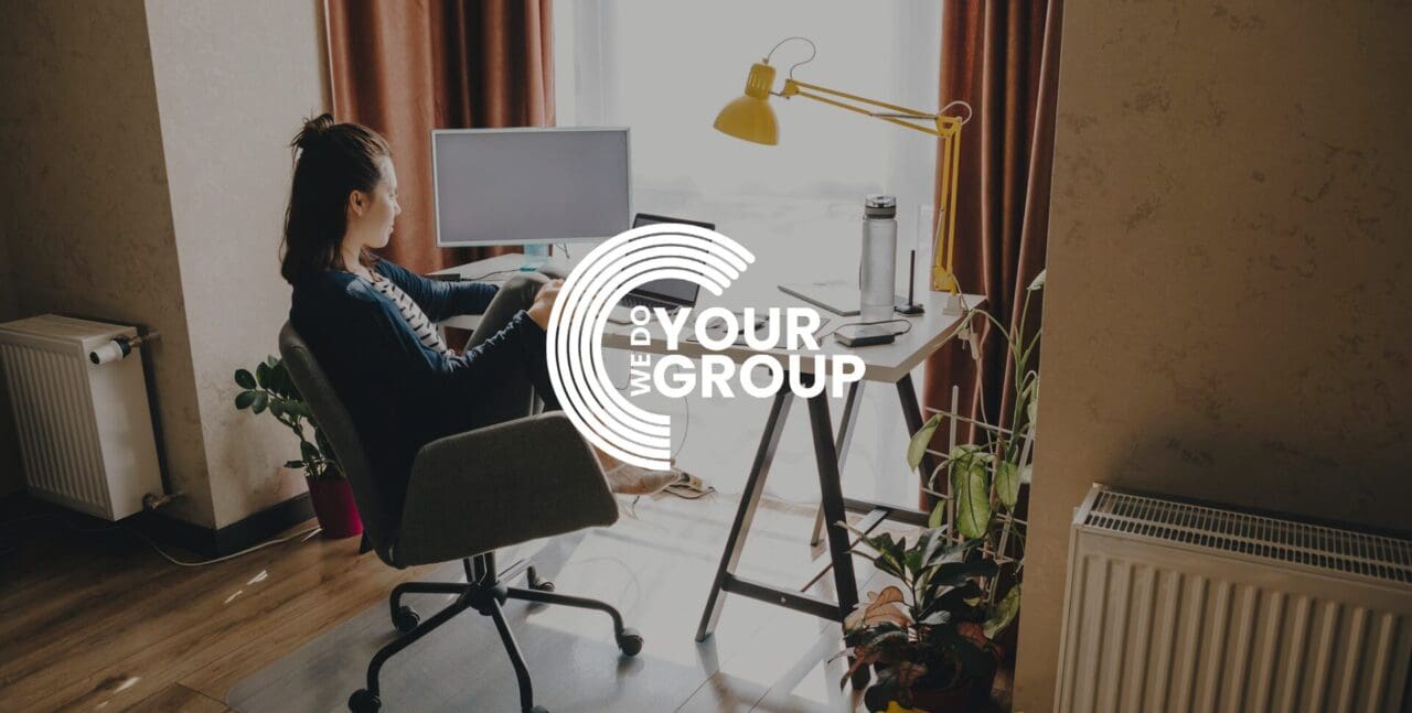 WeDoYourGroup white logo on background of woman sat at home desk, using Mac laptop