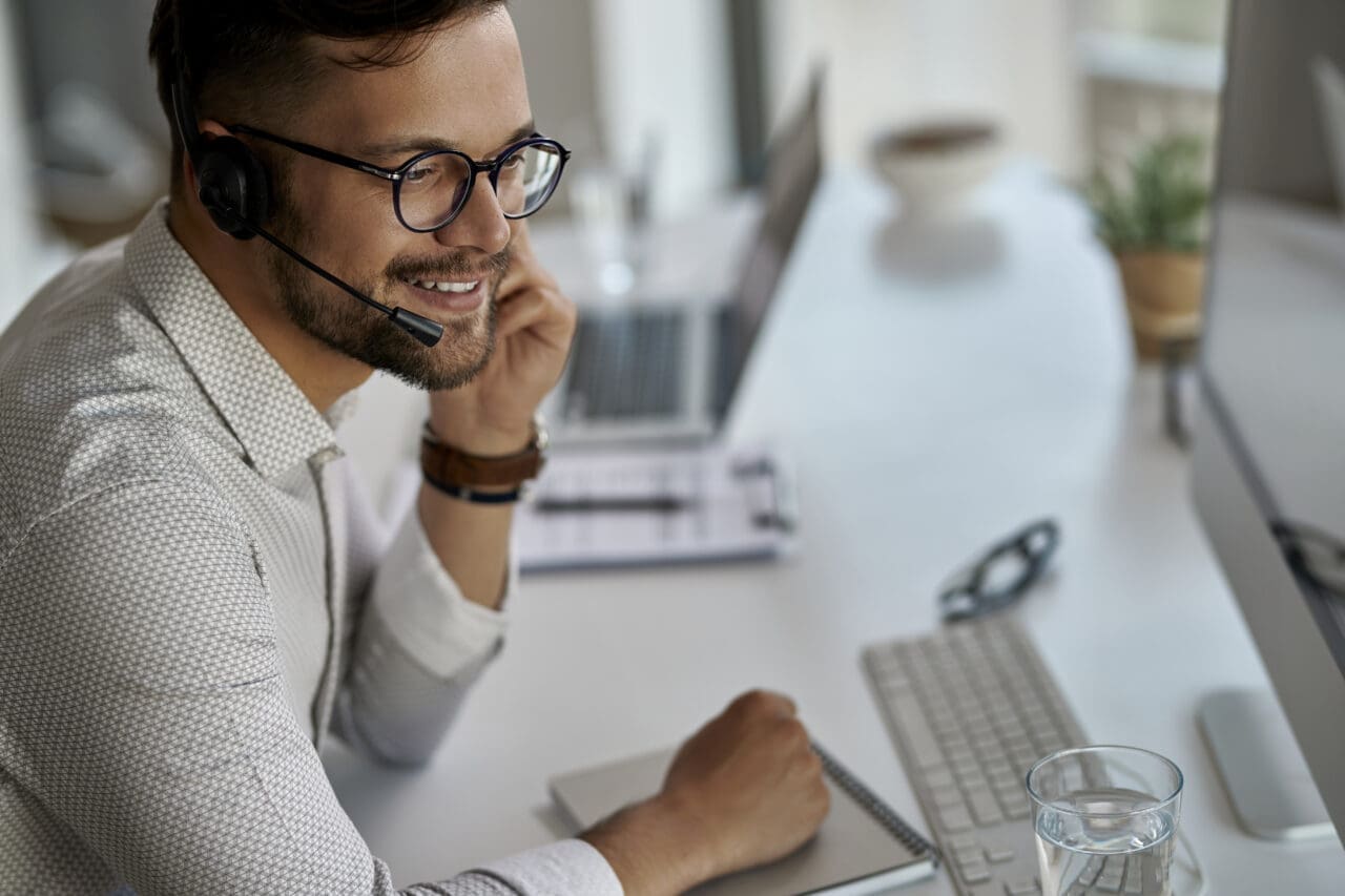 Smiling businessman speaking to customer on telephone headset