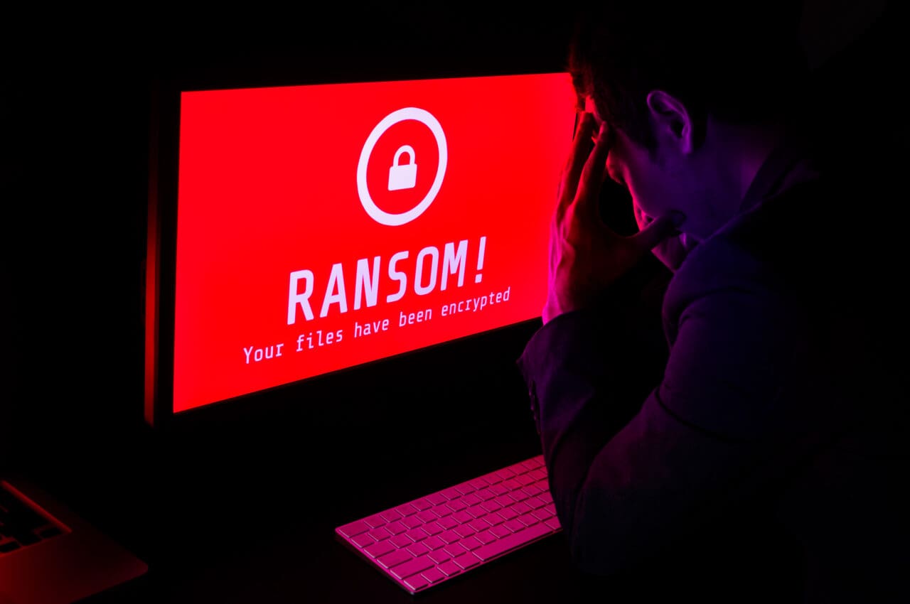 Computer screen with message 'Ransom! Your files have been encrypted', red background on the screen