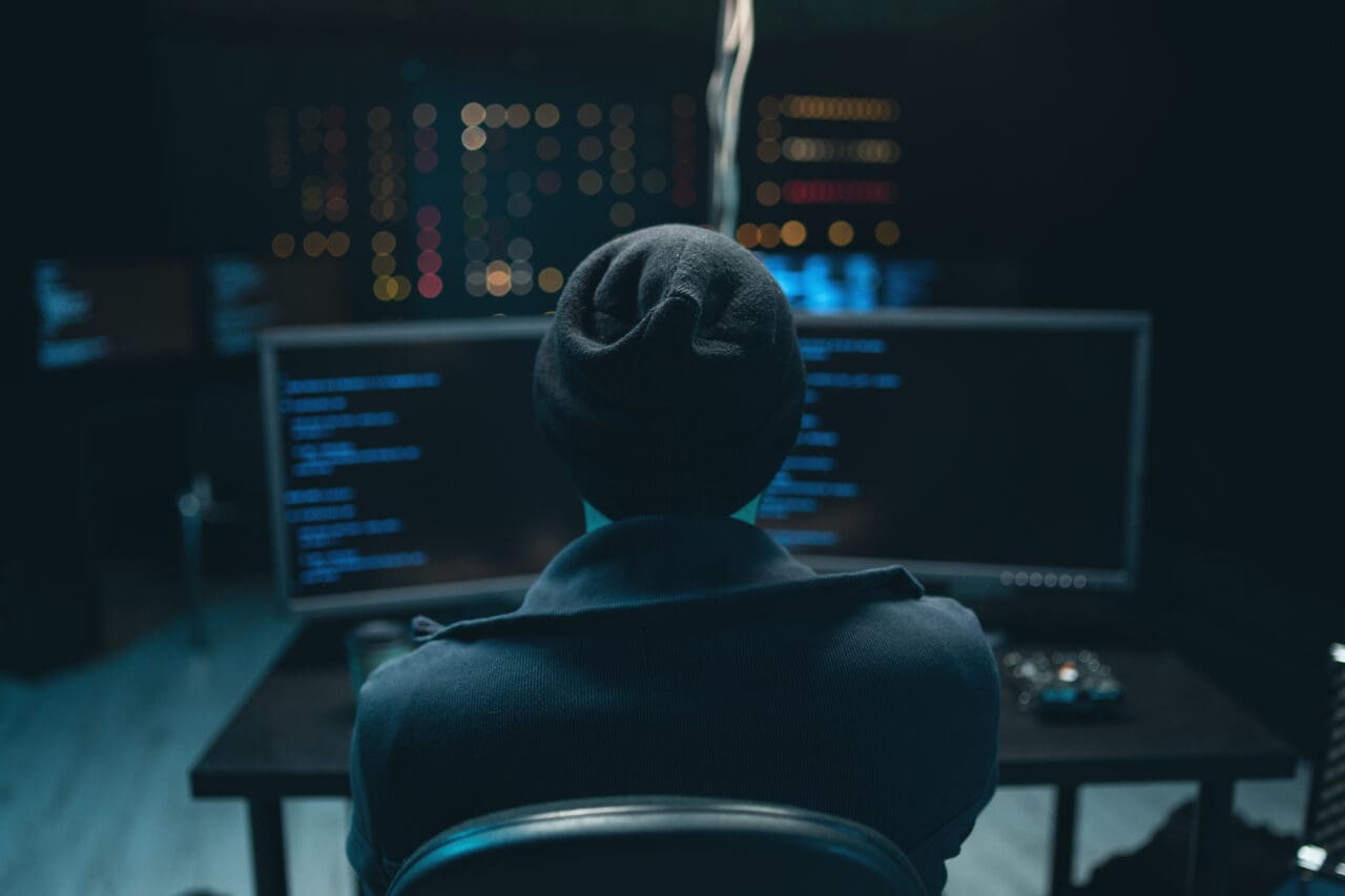 Dangerous Hooded Hacker coding virus ransomware on computers