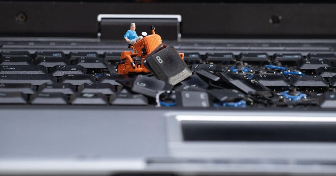Toy man on digger, ripping up keys on a keyboard
