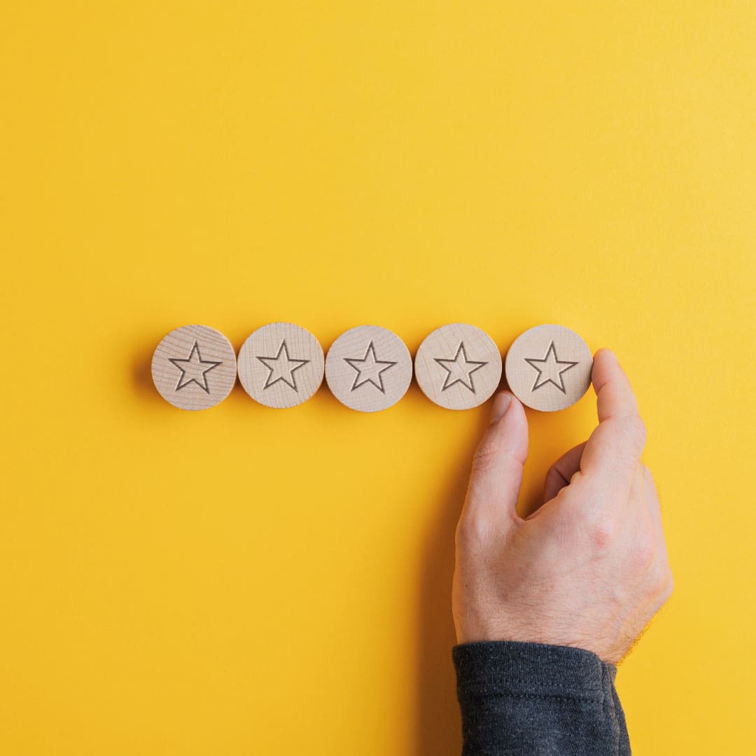 Row of 5 wooden stars on a yellow background