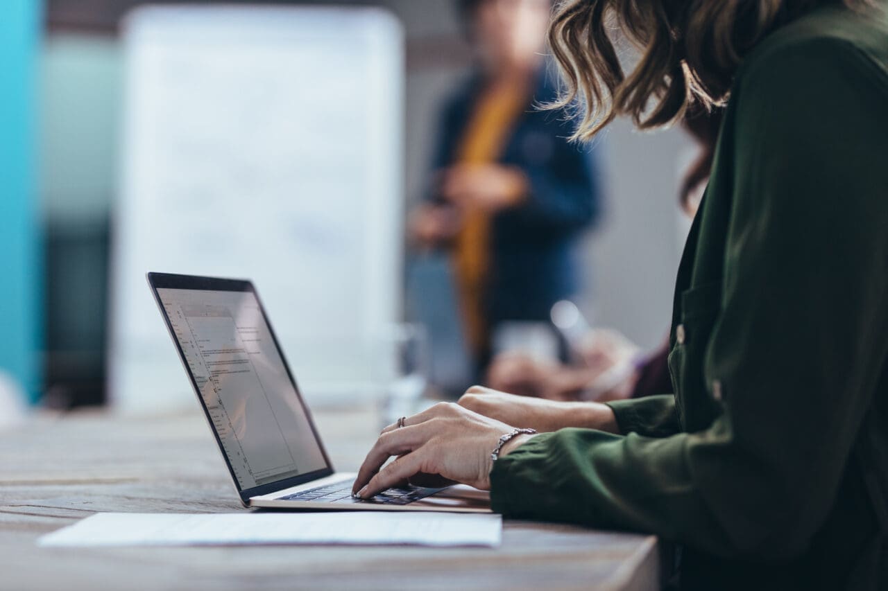 Female executive using Mac laptop during a presentation