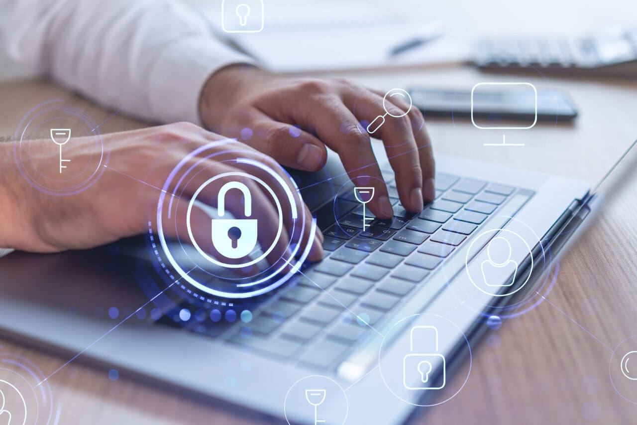 A programmer is typing a code on computer to protect a cyber security from hacker attacks and save clients confidential data. Padlock Hologram icons over the typing hands