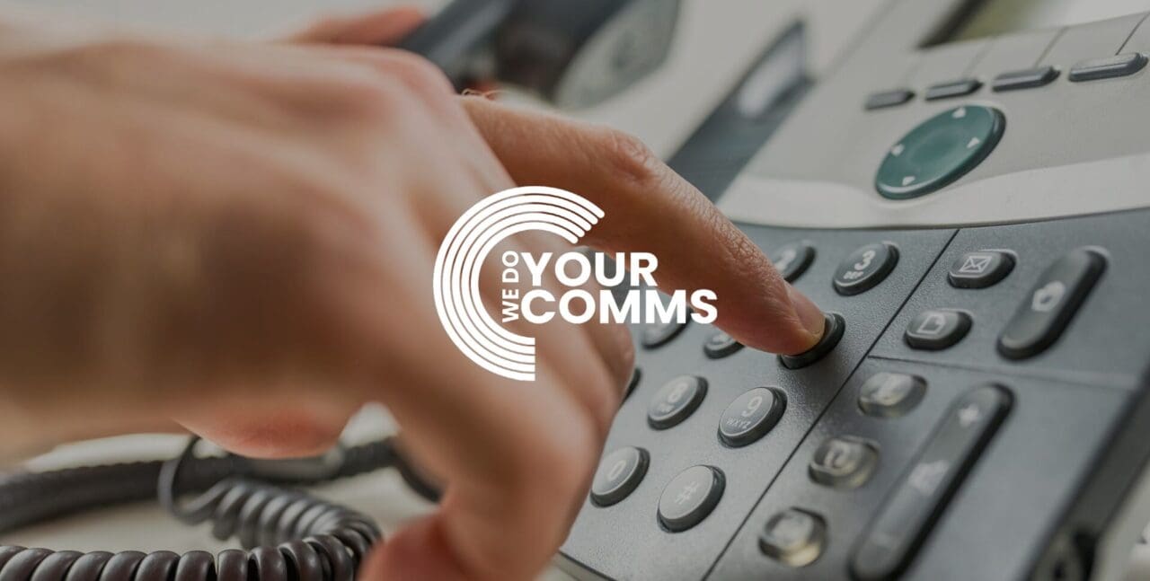 WeDoYourComms white logo on background of man pressing number on telephone handset