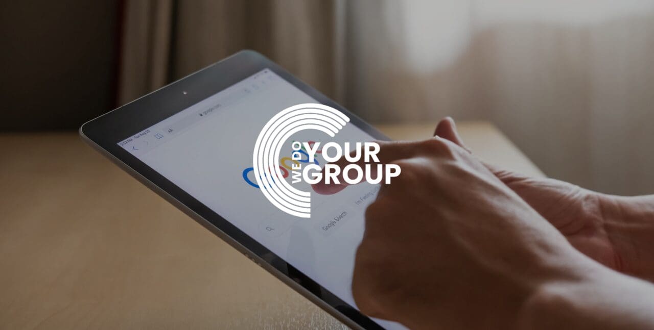 WeDoYourGroup white logo with man pressing on tablet; Google search bar on screen