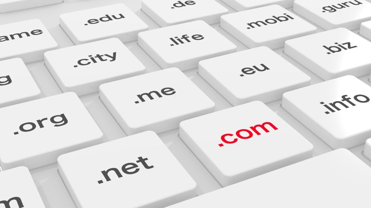 White computer keyboard with different domain endings and a red com key 3D illustration