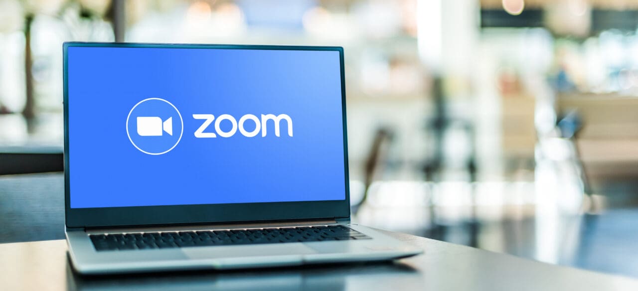 Laptop computer displaying logo of Zoom, videotelephony and online chat services through a cloud-based peer-to-peer software platform