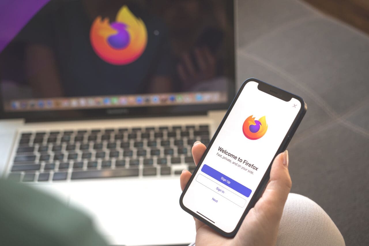 Firefox app logo on mobile phone screen. Woman using Firefox browser application