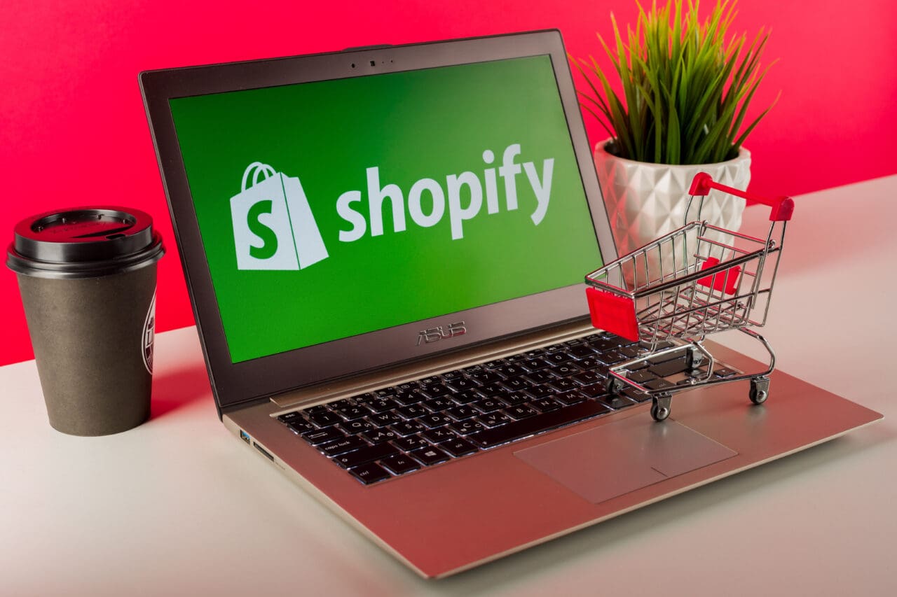 Shopify logo displayed on a modern laptop on desk