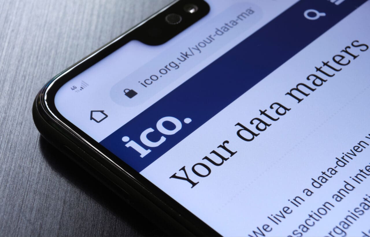 The Information Commissioner's Office ICO website seen on the smartphone corner. The UK watchdog which protects information rights and data privacy