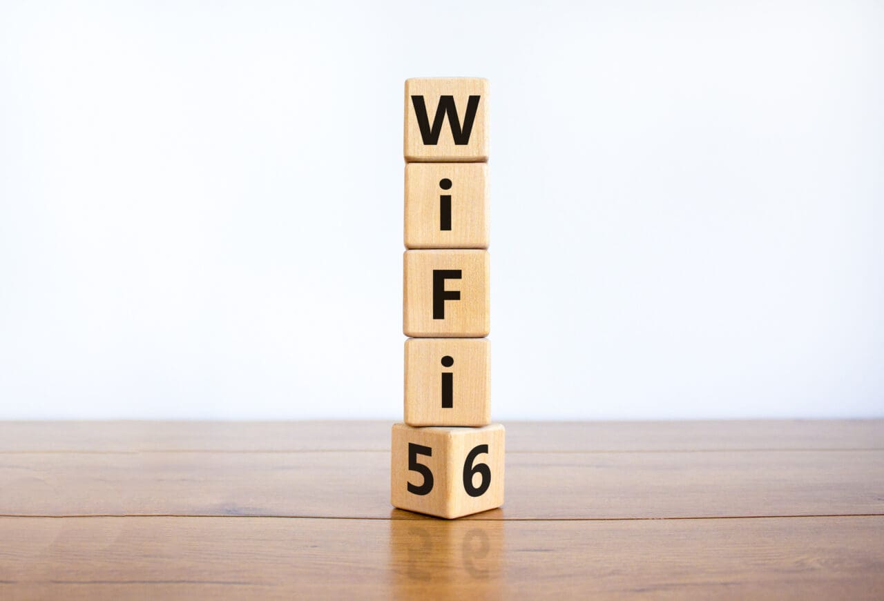 WiFi 5 or 6 symbol. Turned a wooden cube and changed the words WiFi 5 to WiFi 6. Placed on wooden table, white background