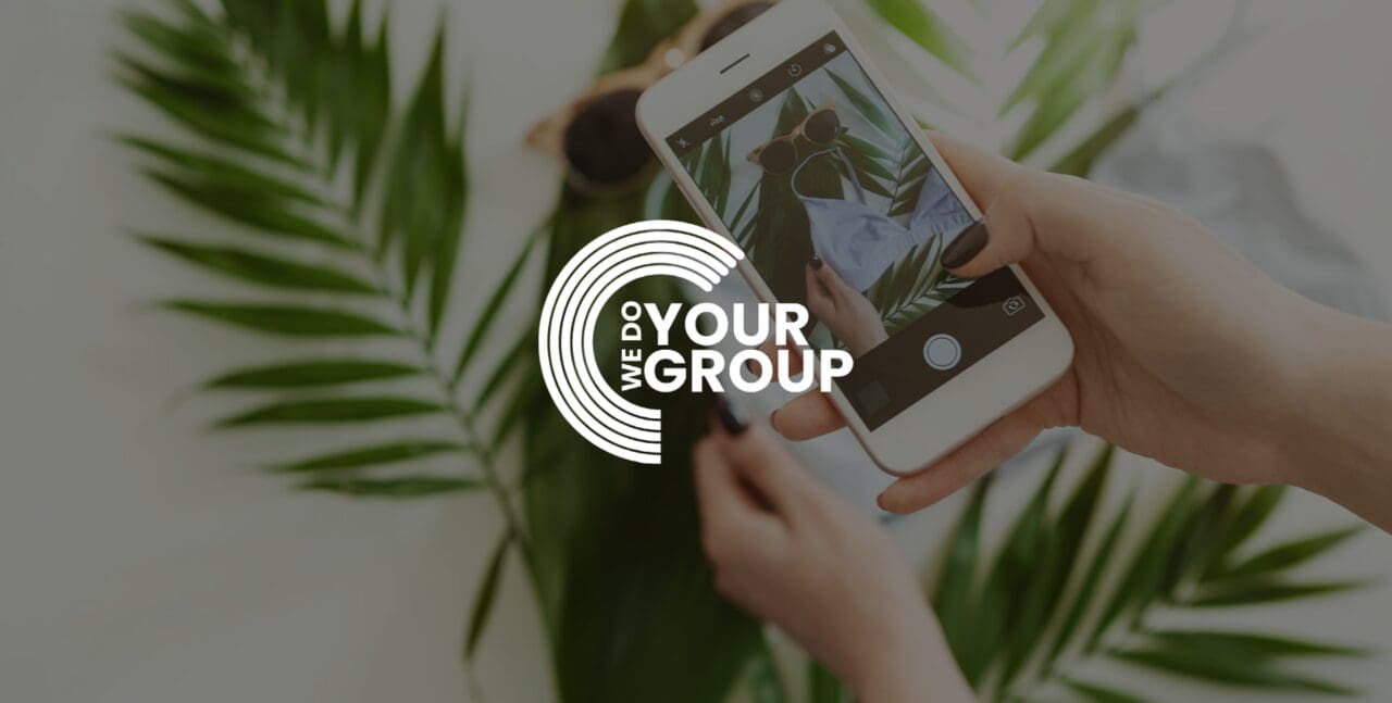 WeDoYourGroup white logo on background of woman taking photo of plant on her mobile phone