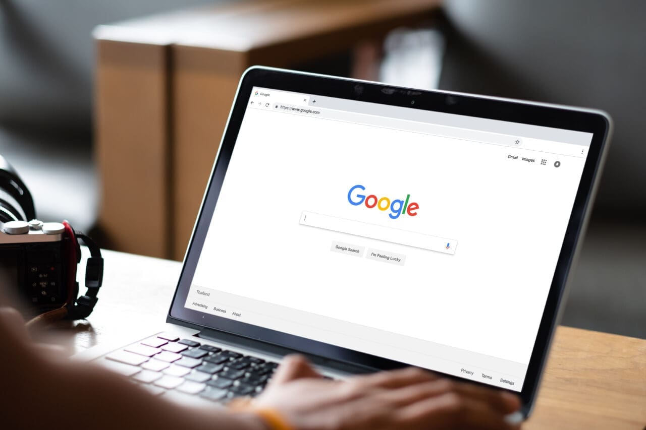 Man typing on Google search on his Mac laptop