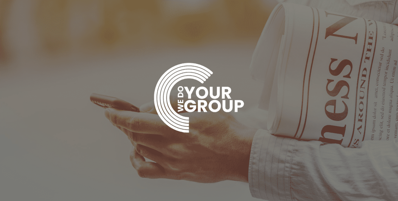 WeDoYourGroup white logo on background of man holding mobile phone with newspaper in his arm