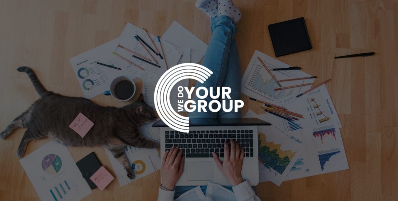 WeDoYourGroup white logo on background with lady sat on the floor with mac laptop on her lap, paper graphs surrounding her and her cat led down