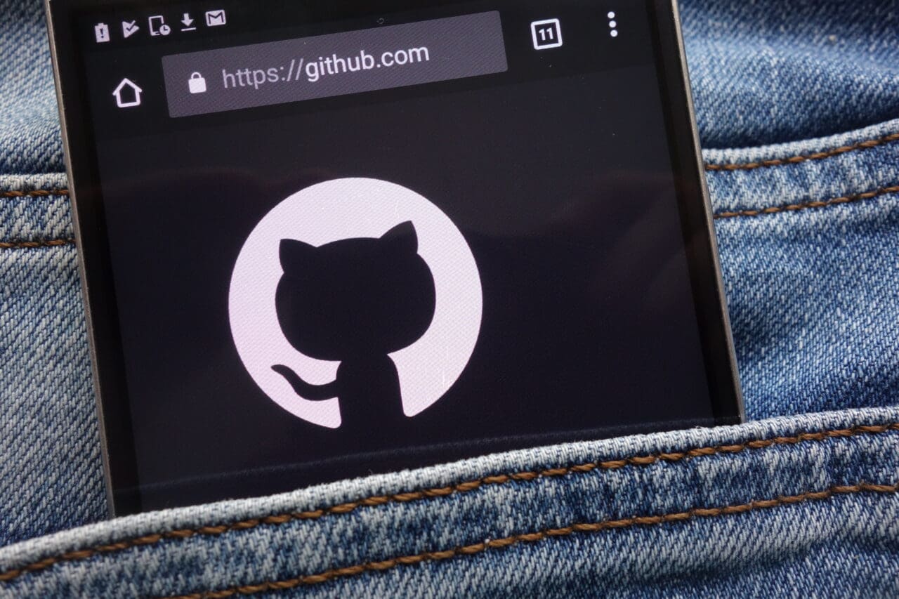 GitHub logo on mobile phone in jean pocket