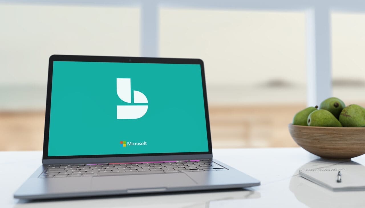 Open laptop on desk with Microsoft symbol on screen