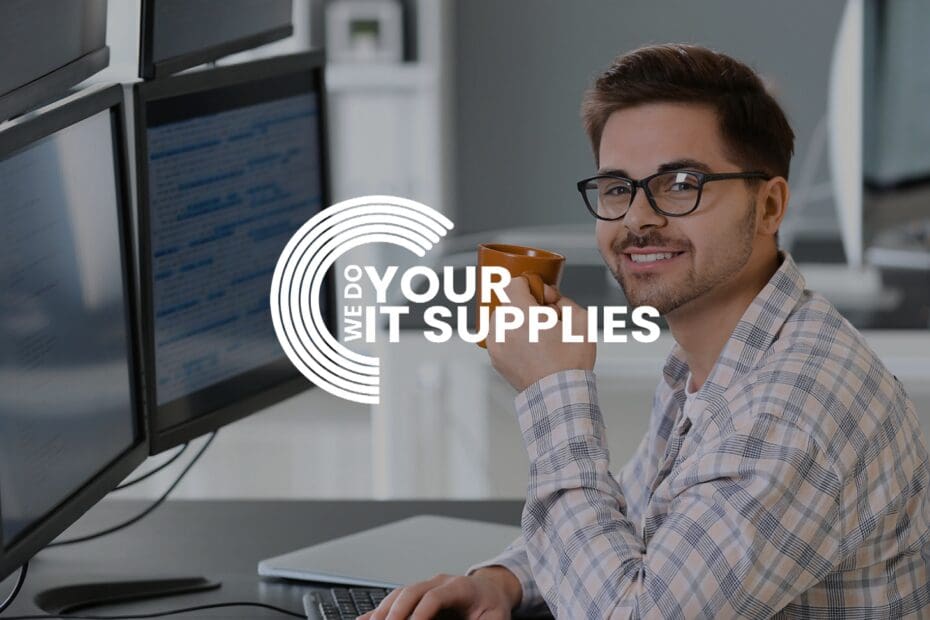 WeDoYourITSupplies white logo on background of man smiling at the camera, at his desk