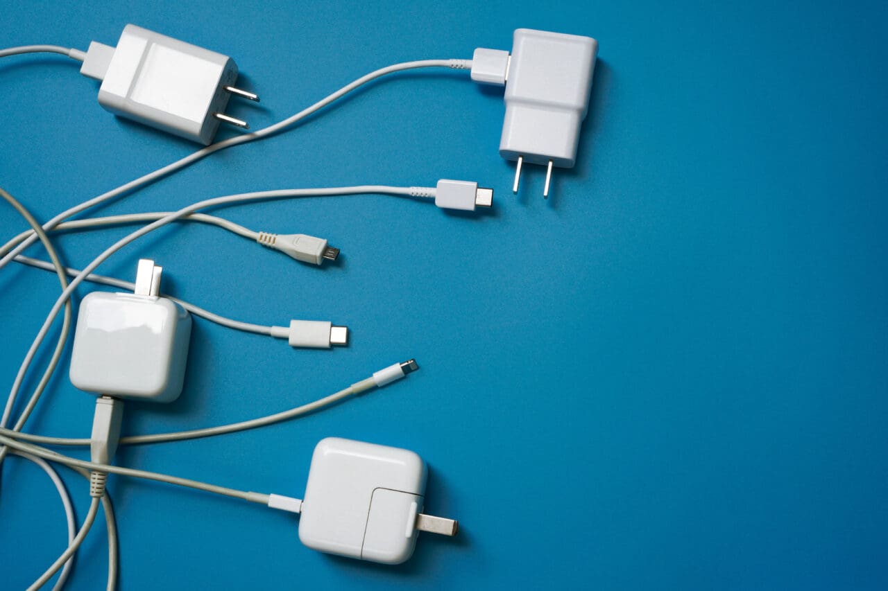 Multiple white charging cables on blue background