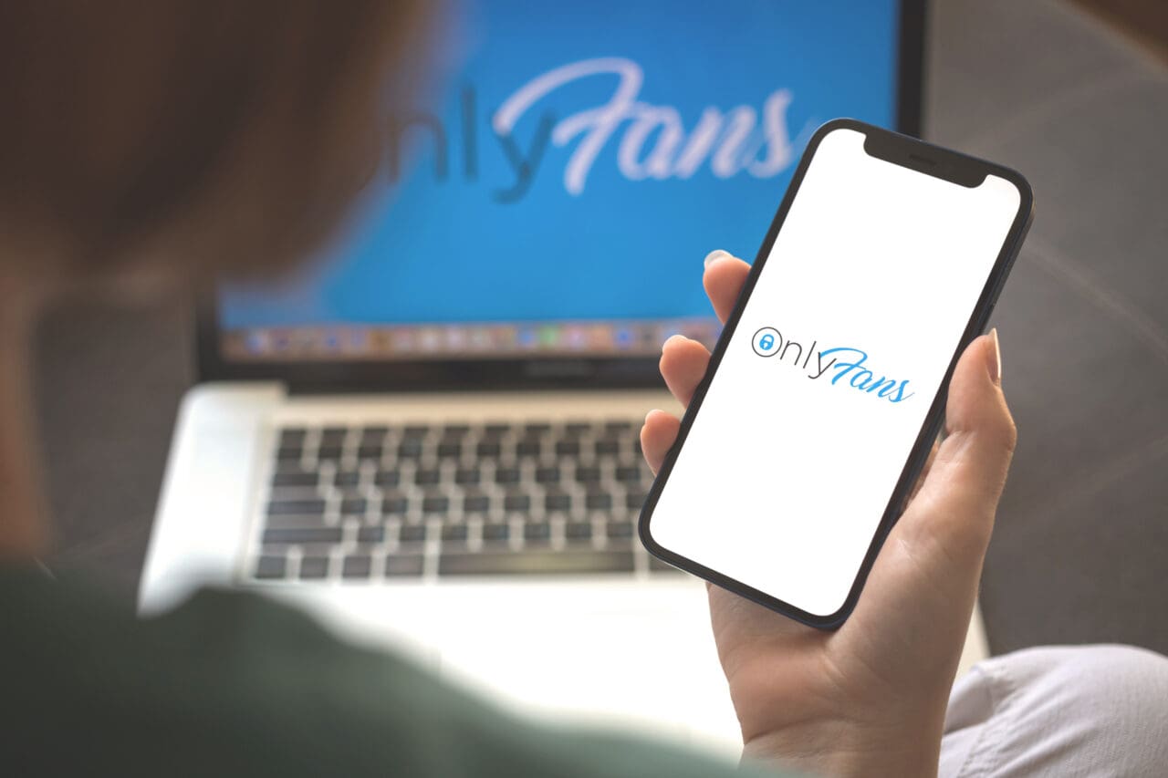 Woman using Onlyfans application. Onlyfans app logo, mobile phone screen