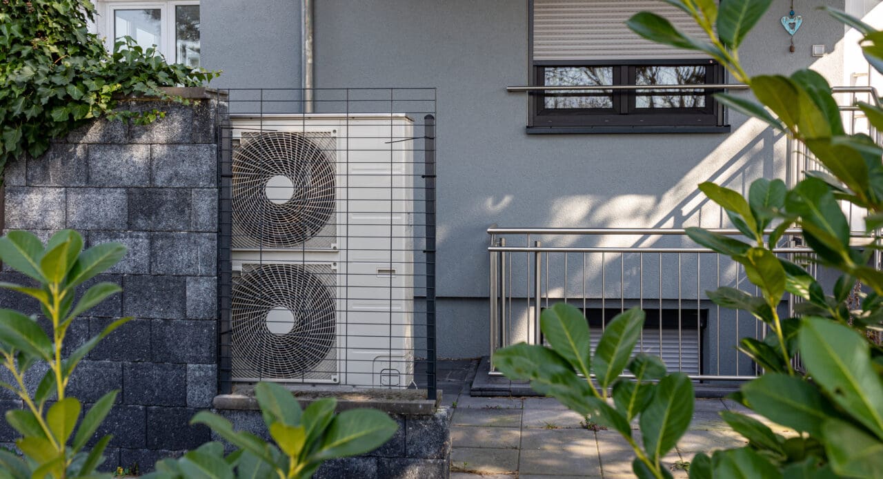 Air source heat pumps installed on the garden front of a modern building