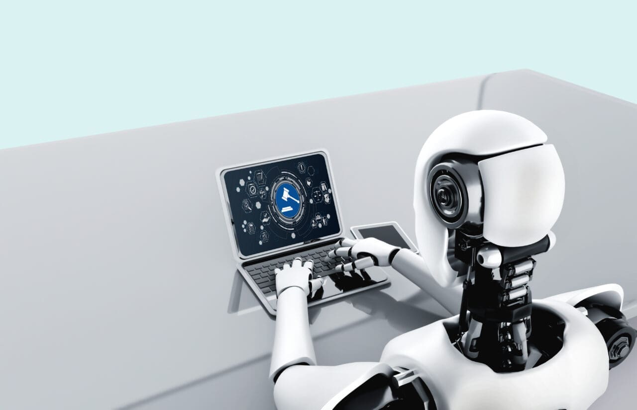 Cartoon image of white robot typing on small laptop with icons on the screen