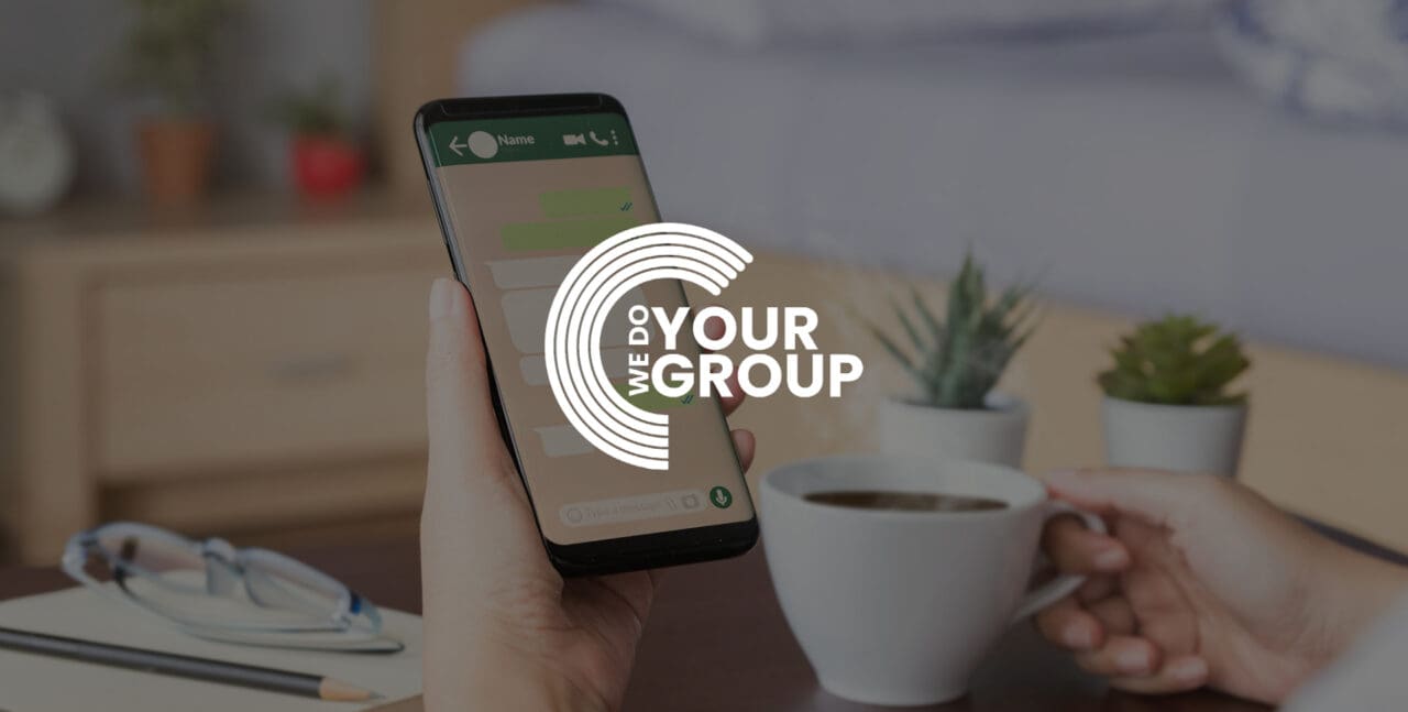 WeDoYourGroup white logo on background of whatsapp on a mobile phone