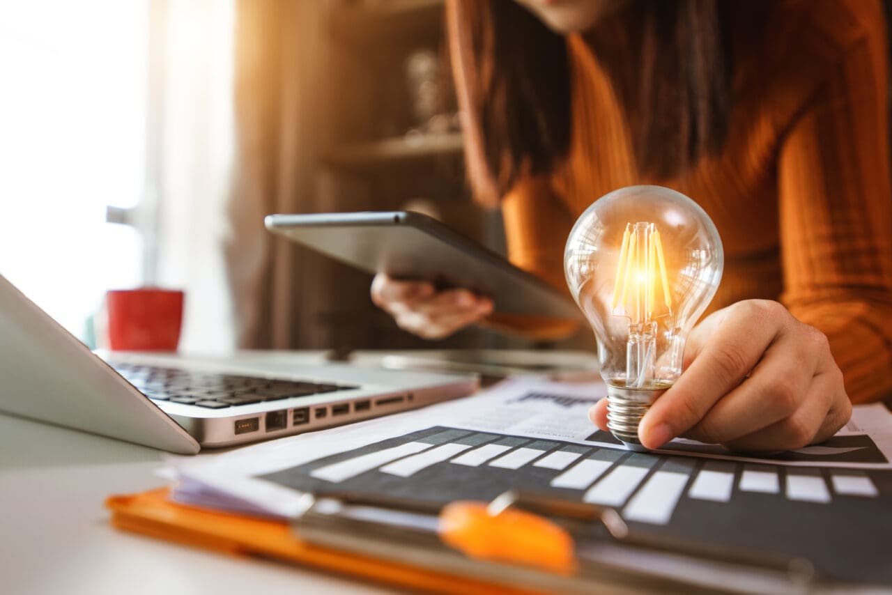 business man using smartphone, tablet and holding light bulb, wi