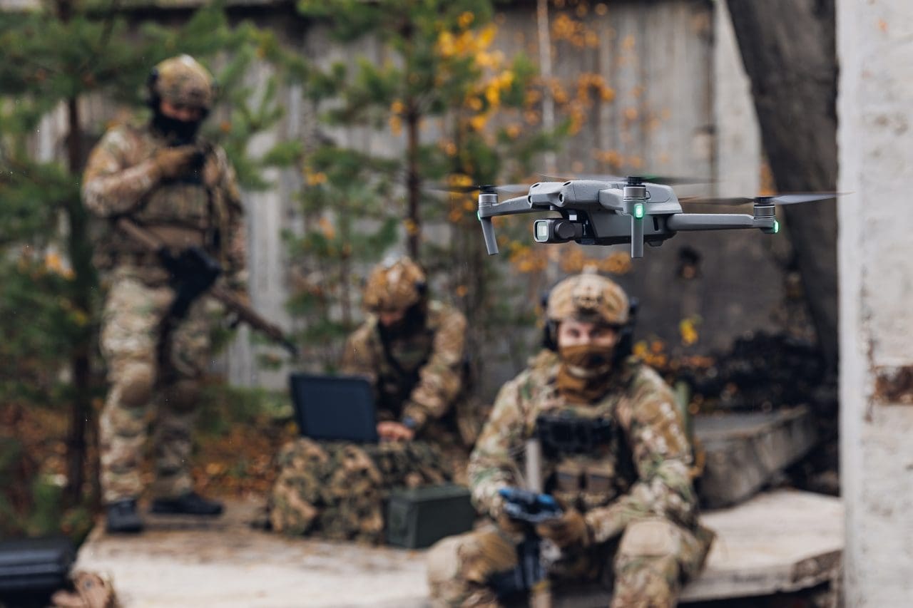 Military soldier controls drone for reconnaissance operation of enemy positions. Concept using quadrocopters in smart war