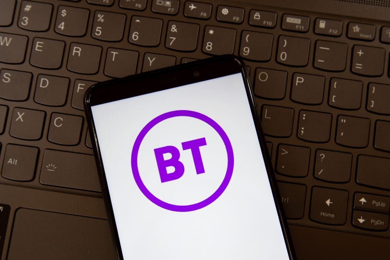 BT logo on the smartphone screen on a keyboard. Group plc is a British multinational telecommunications holding company.