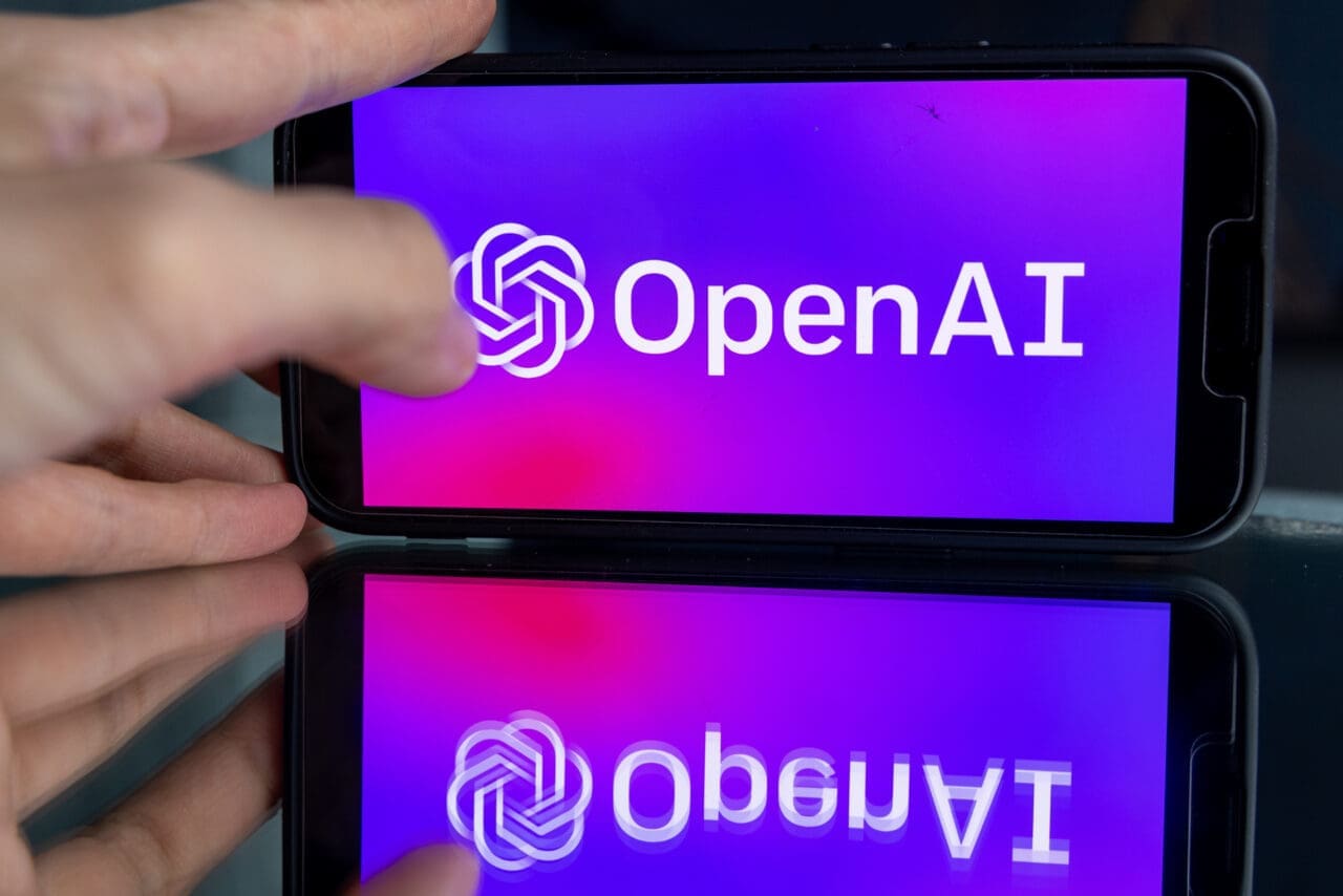 Woman's hand holding an iPhone with OpenAI logo. ChatGPT and Chat bot culture, artificial intelligence time.