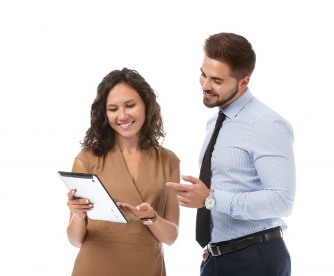 Image of a young man and young woman smiling and talking looking at an iPad
